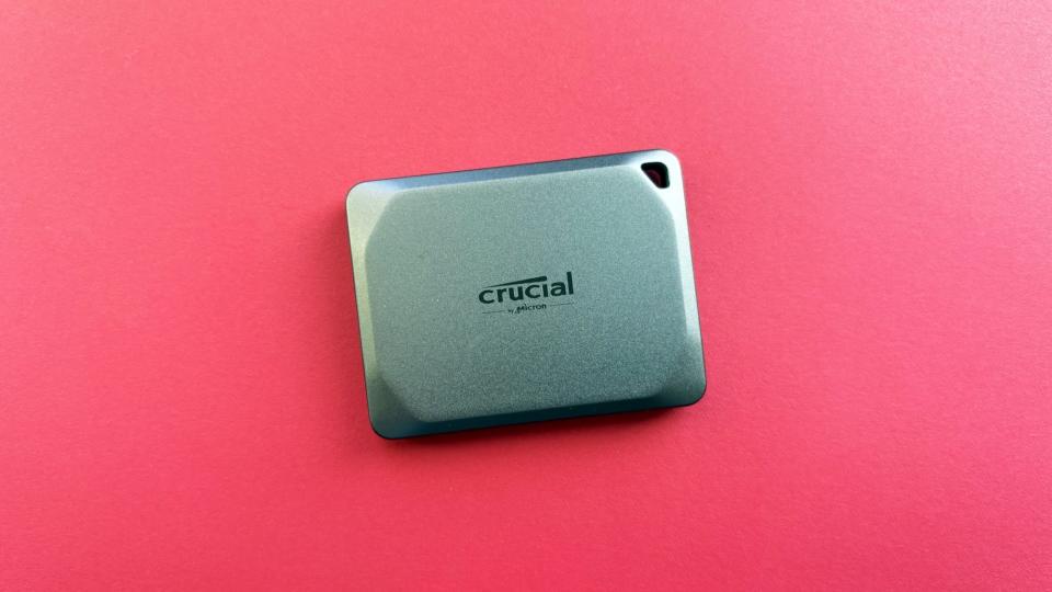 The Crucial X9 Pro portable against a red background.